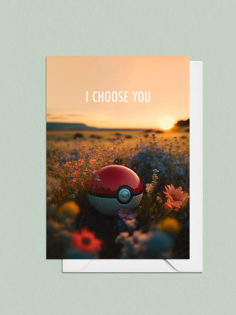 A greeting card featuring a Poke Ball sitting in a field of wild flowers with words saying: I choose you