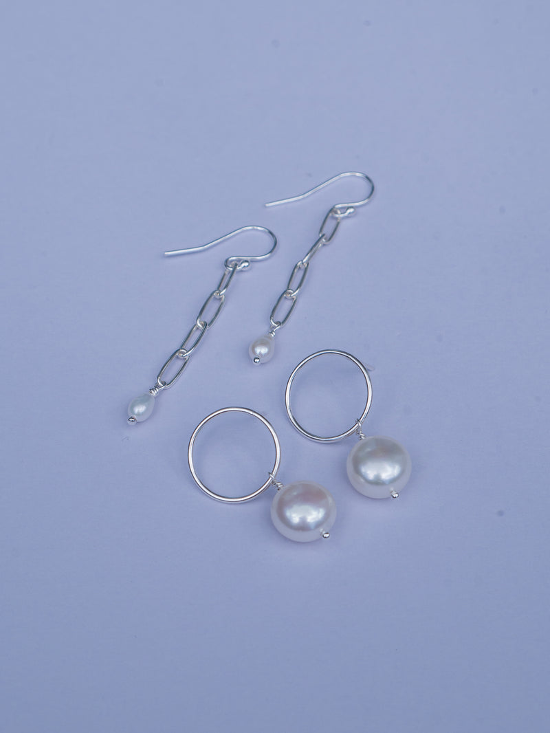 White freshwater pearls freely hang from sterling silver circle stud and chain earrings